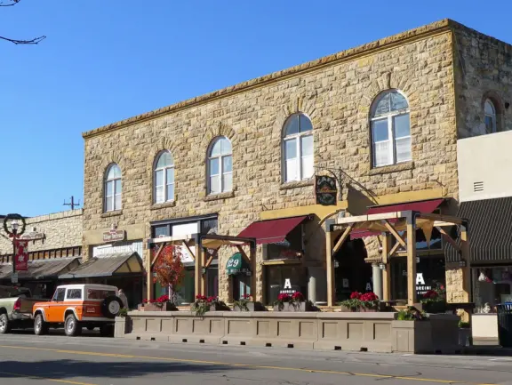 Nice little main street, with cafes, pretty storefronts, park, swinging bridge over a creek with tropical vegetation, and neighborhood with white picket fences and gardens.