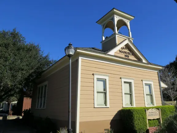 Nice little main street, with cafes, pretty storefronts, park, swinging bridge over a creek with tropical vegetation, and neighborhood with white picket fences and gardens.