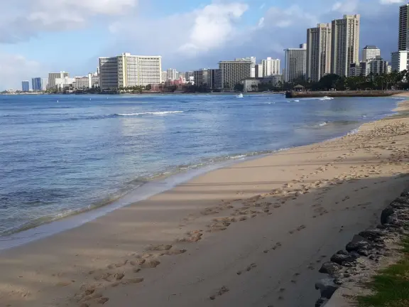 A jetty with a gazebo on the end, in the heart of Waikiki Beach. A popular bodyboarding and snorkeling spot where the reef is inches from your knees!