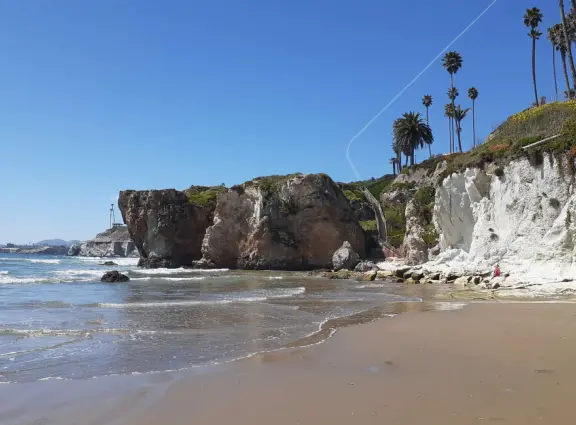 Stairs surrounded by purple and yellow ice plant, leading down to Pismo Beach. Volleyball, long walks, caves, pier and boardwalk.