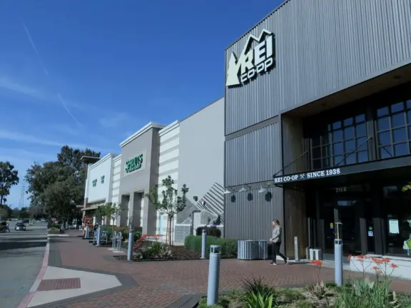 An outdoor shopping plaza with many fun stores.