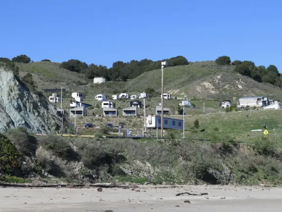 Empty no-dogs-allowed beach with cute rocky area on the left.
