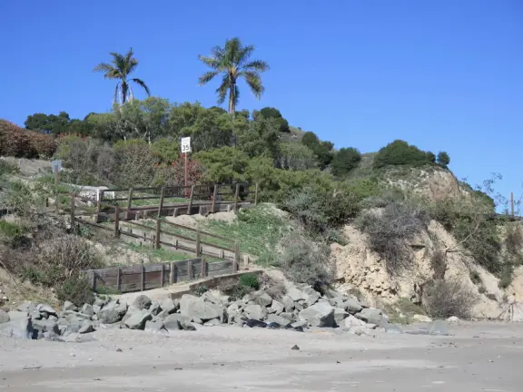 Empty no-dogs-allowed beach with cute rocky area on the left.