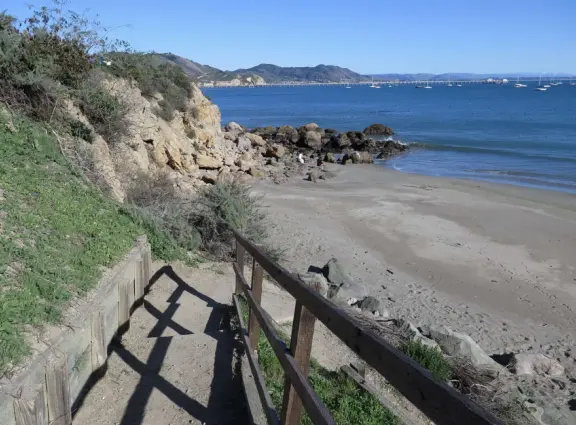Empty no-dogs-allowed beach with cute rocky area on the left.
