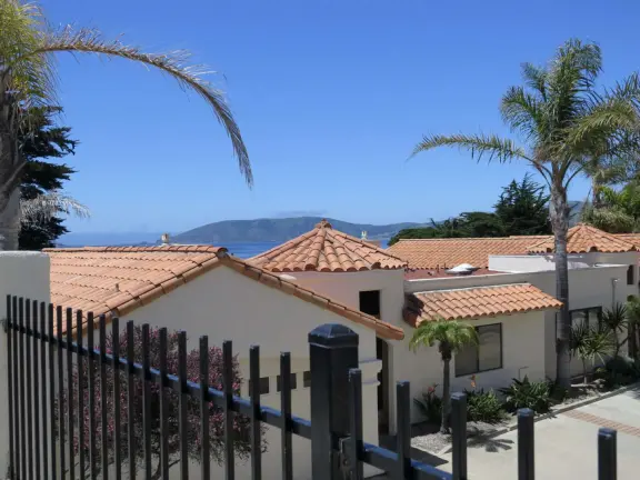 Stretch of grass with a paved walkway, flower beds, wonderful ocean views to Avila Beach, and monterey cypress trees.