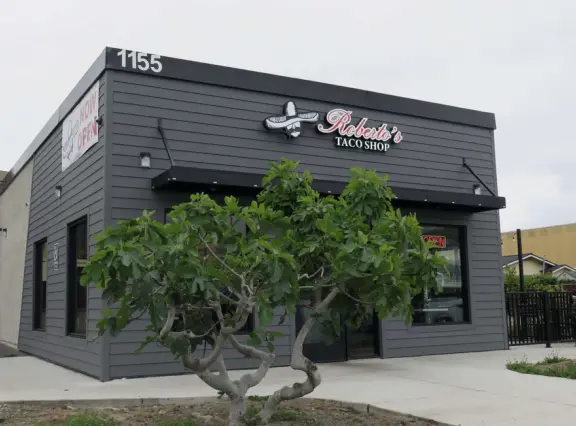 Wealthy neighborhood with cliffs covered in wildflowers above the turquoise sea.