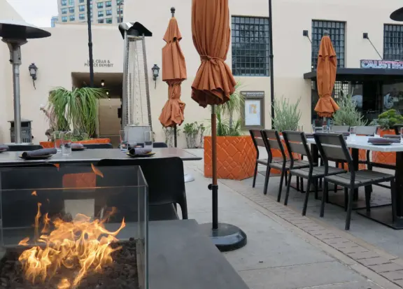 A Spanish-style plaza with cafes and shops, in a historic police headquarters complex.