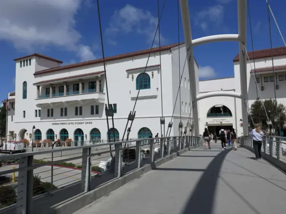 Modern campus with tropical blooming trees and Spanish architecture on the northern end of campus.