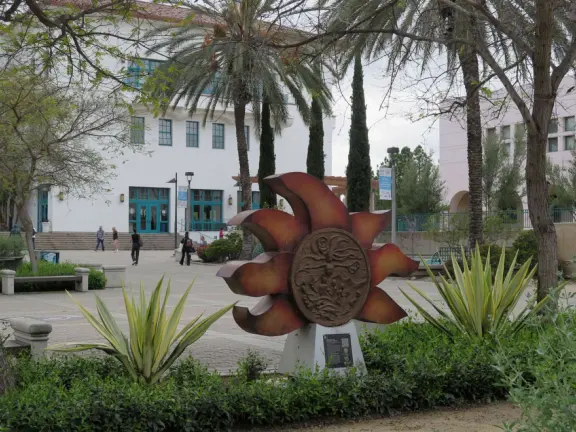 Modern campus with tropical blooming trees and Spanish architecture on the northern end of campus.