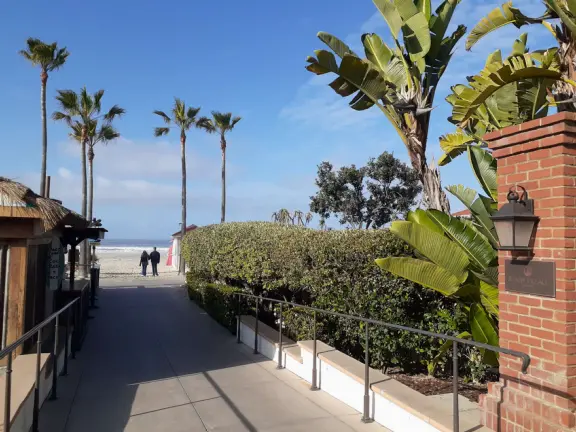 Historic resort with red turrets on foggy beach of fine white sand.