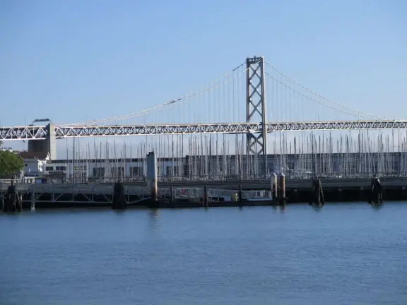 Modern area, also called Mission Bay, with French bakery, waterfront bike path that connects to Embarcadero, and views across to Oracle Park stadium and the Bay Bridge.