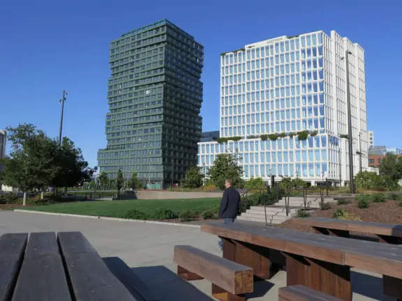 Modern area, also called Mission Bay, with French bakery, waterfront bike path that connects to Embarcadero, and views across to Oracle Park stadium and the Bay Bridge.