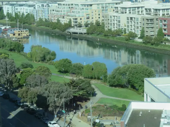 Modern area, also called Mission Bay, with French bakery, waterfront bike path that connects to Embarcadero, and views across to Oracle Park stadium and the Bay Bridge.
