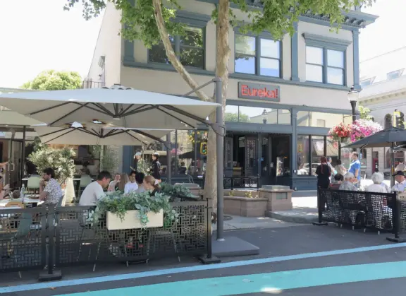 Pedestrian-only area with cafes, flowers baskets, and street musicians.