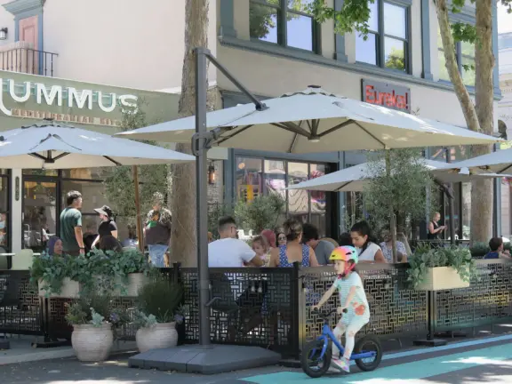 Pedestrian-only area with cafes, flowers baskets, and street musicians.