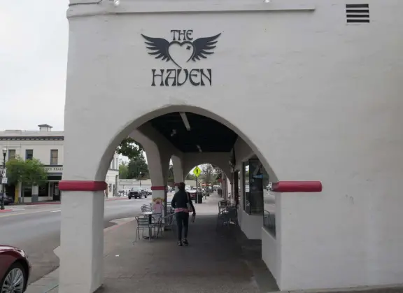 Nice little main street, with cafes, pretty storefronts, park, swinging bridge over a creek with tropical vegetation, and neighborhood with white picket fences and gardens.