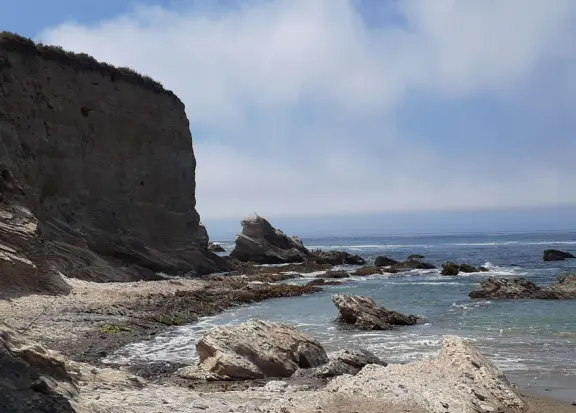 Rugged, beautiful cove with interesting rocks, sea glass, and shells on shore. Rock to climb, and water rushing into cove.