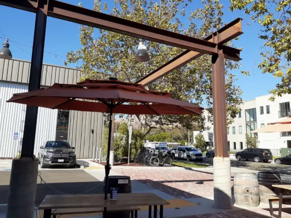 Trendy area with coffee shop, beer garden, wine bars, and cider bar, in industrial-style architecture with murals.