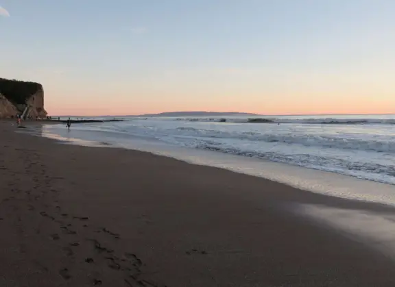 Stretch of grass with a paved walkway, flower beds, wonderful ocean views to Avila Beach, and monterey cypress trees.
