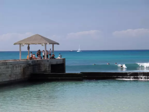 A jetty with a gazebo on the end, in the heart of Waikiki Beach. A popular bodyboarding and snorkeling spot where the reef is inches from your knees!