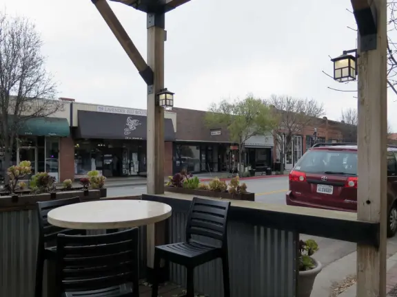 Nice little main street, with cafes, pretty storefronts, park, swinging bridge over a creek with tropical vegetation, and neighborhood with white picket fences and gardens.