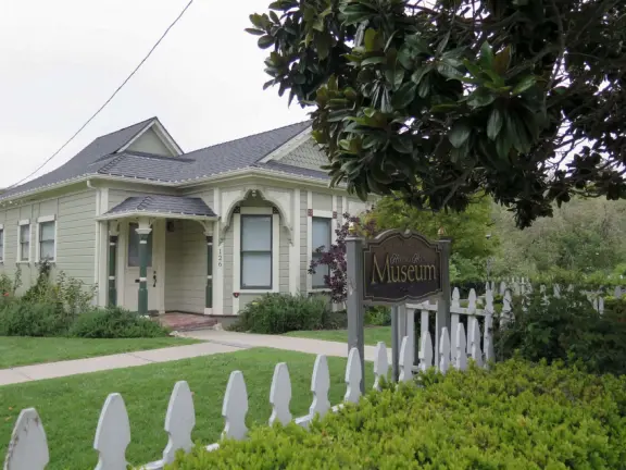 Large lush park with tall tropical trees, attractive bandstand, cute toddler playground, historic house and schoolhouse, swinging bridge to the main street, and neighborhood with cottages.