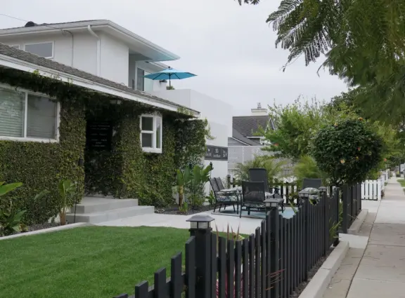 Large lush park with tall tropical trees, attractive bandstand, cute toddler playground, historic house and schoolhouse, swinging bridge to the main street, and neighborhood with cottages.