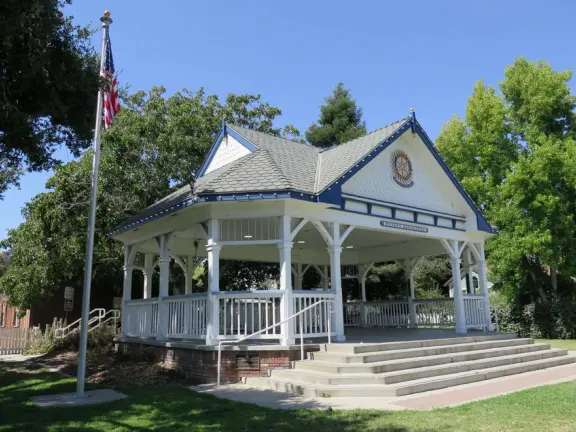Large lush park with tall tropical trees, attractive bandstand, cute toddler playground, historic house and schoolhouse, swinging bridge to the main street, and neighborhood with cottages.