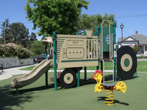 Large lush park with tall tropical trees, attractive bandstand, cute toddler playground, historic house and schoolhouse, swinging bridge to the main street, and neighborhood with cottages.