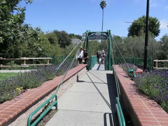 Large lush park with tall tropical trees, attractive bandstand, cute toddler playground, historic house and schoolhouse, swinging bridge to the main street, and neighborhood with cottages.