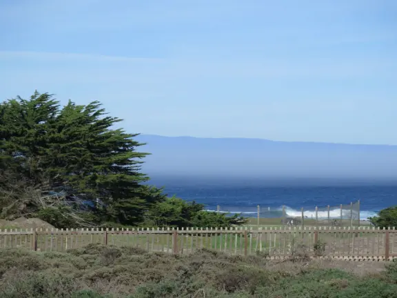 A beautiful, well-cared-for lighthouse with idyllic views of the golf course, dunes, and sea, and a garden with bright flowers.