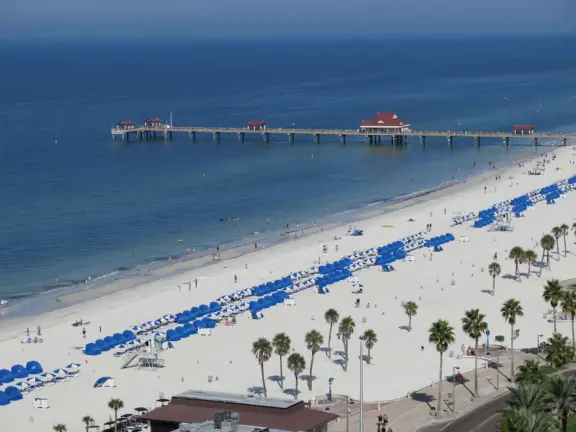 White sand beach with popular boardwalk, modern highrise hotels, fishing pier, and crab shack restaurants.