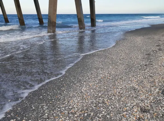 Beach with cute pier and aquamarine water.