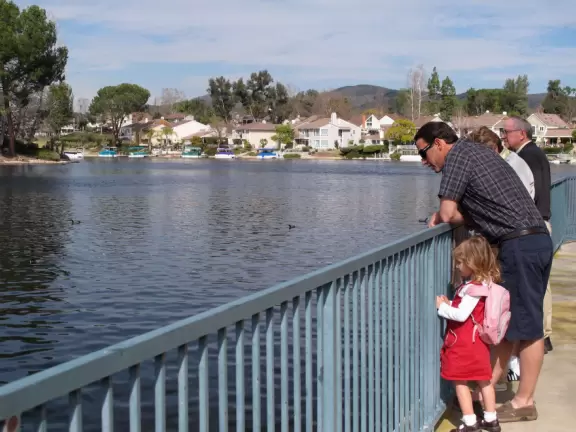 A scenic walkway plus restaurants beside a lake that is part of a McMansion development.
