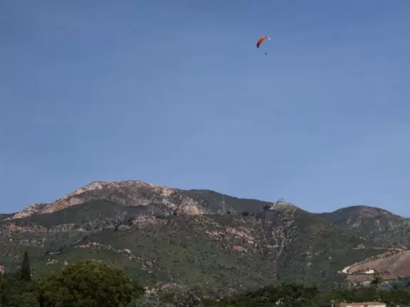 Walk in wide open spaces past boulders and flowers with views of historic Spanish-style water reservoir and mountains.