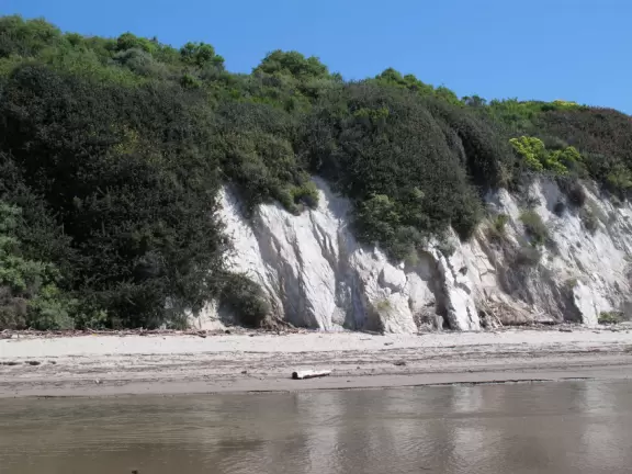 Festive beach with white cliffs, popular playground, pier, and cafe coming soon.