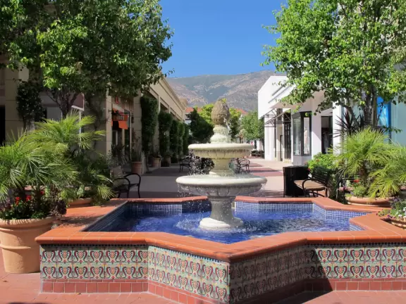 A pretty mall filled with flower pots and giant sized games, with views of the mountains and plenty of stores for kids!
