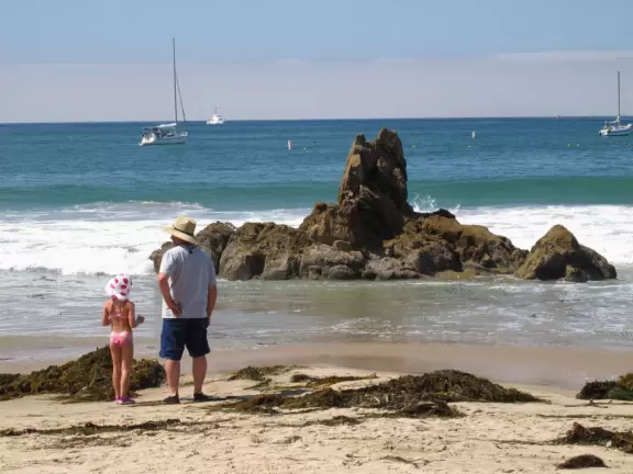 Walk a steep path with lovely views down to a popular beach where kids play in the sand and bodyboard.