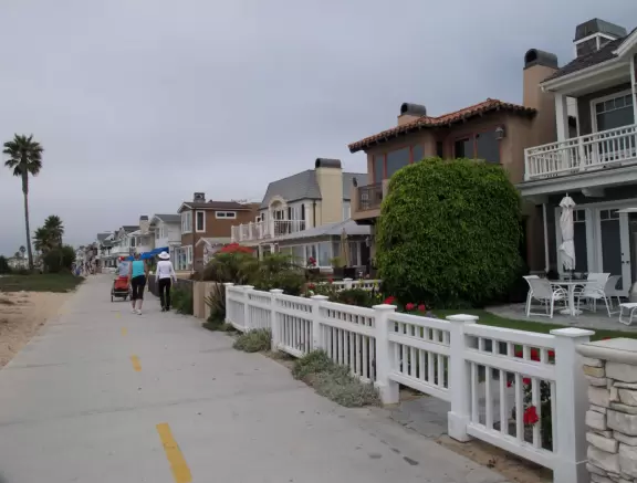 Outdated area with ferris wheel, carousel, boardwalk between beachhouses and the beach, pier, and nice walking path along the harbor.