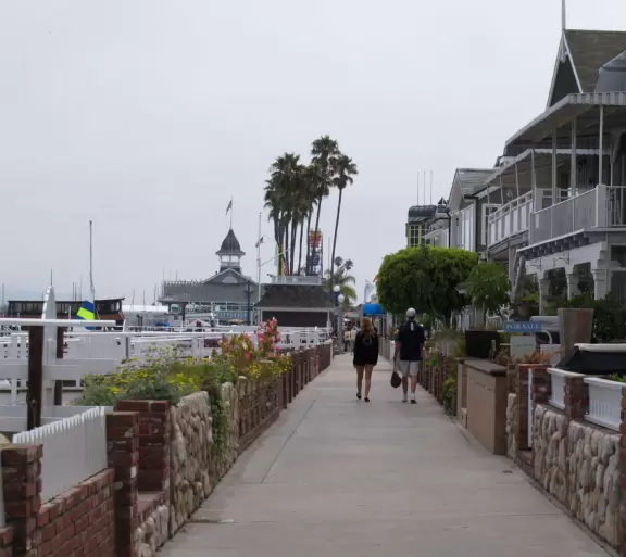 Outdated area with ferris wheel, carousel, boardwalk between beachhouses and the beach, pier, and nice walking path along the harbor.