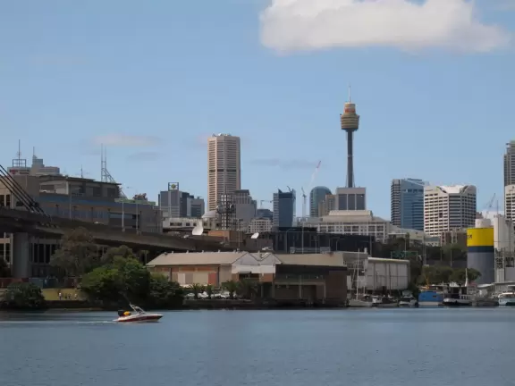 Gorgeous views of the city skyline and Anzac Bridge from a cement walking path alongside the water.