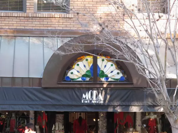 Gorgeous main street with large, European-style park where people sit on the grass by the fountain.