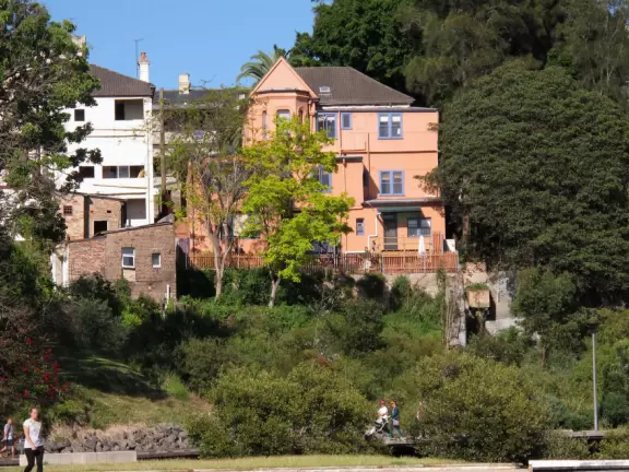 Gorgeous views of the city skyline and Anzac Bridge from a cement walking path alongside the water.