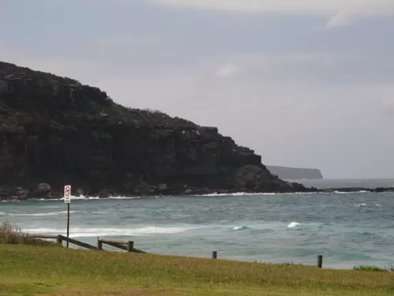 Windy beach with walking paths to high sand dunes and Barrenjoey lighthouse.
