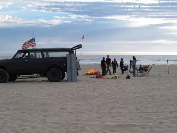 Rugged sand-swept place with high dunes, popular with off-road vehicle enthusiasts.
