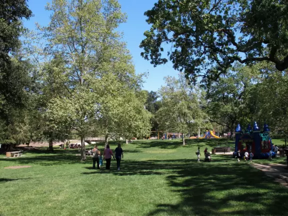 A large park with beautiful tall trees, playground with huge slides, gazebo, and a pleasant lake where you can rent paddle boats in summer.