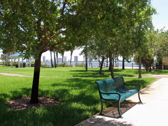 Pretty park along the intracoastal waterway near high rises, with walking paths, playground, gazebos, fountain, and tennis courts.