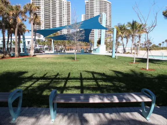 Beach with everything a beach should have: pale sand, aquamarine water, coconut palms, dunes, fit people, and cafes.