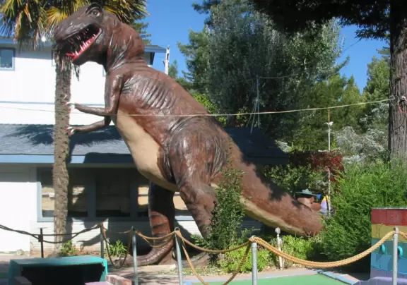 A cute 1940s mini golf park with sculpted animals and water fountains.