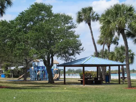 Beautiful area with white sand beach on turquoise river, playground, and small well-cared-for aquarium.